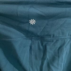 Athleta greenish blue leggings with perforated detail down the leg.